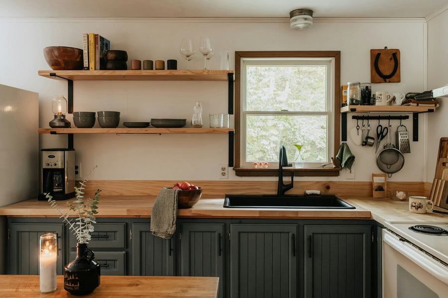 Cozy small kitchen with painted cabinets, wood counters, open shelves, and simple budget-friendly updates