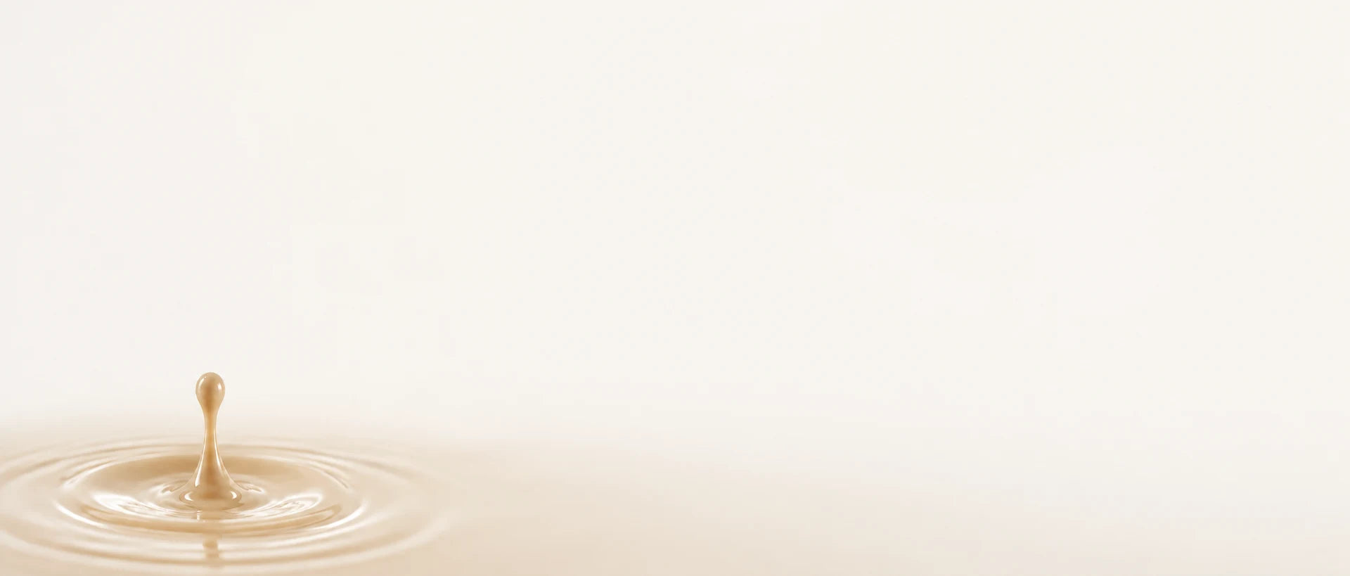 Wide pale background with a coating droplet and ripples at the lower left