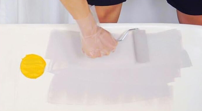 Applying thin even coats of DWIL paint with a roller or brush